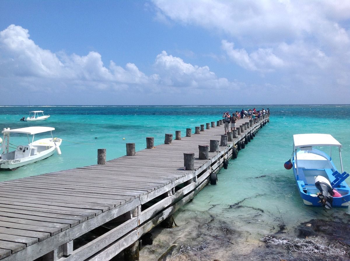 Wooden pier over turquoise reef water in Puerto Morelos, Mexico